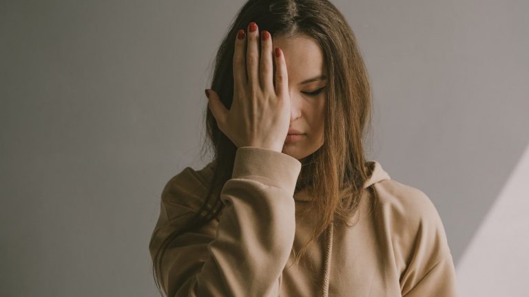 a woman covering her face with her hands
