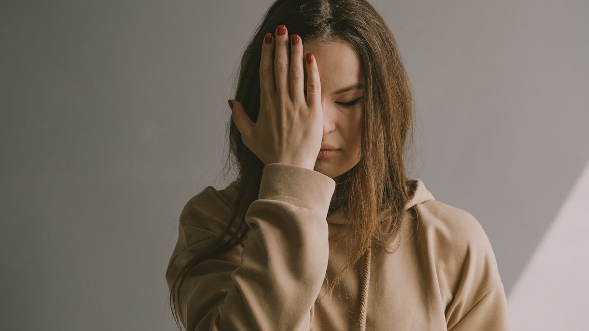 a woman covering her face with her hands